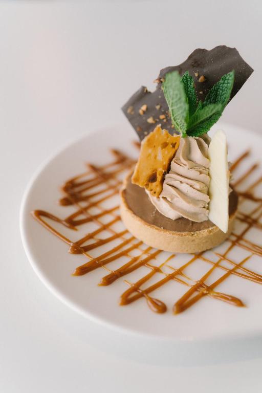 a dessert on a white plate with caramel sauce at Hotel Du Bac in Combrit