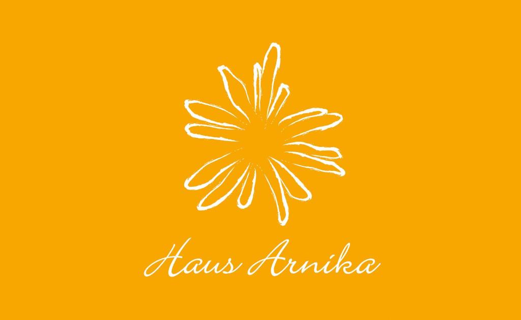 un disegno di un fiore su sfondo arancione di Haus Arnika a Mellau