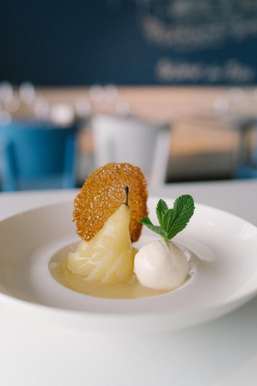 a white plate with a dessert on a table at Hotel Du Bac in Combrit