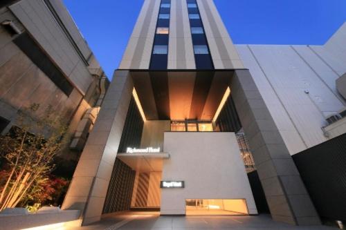 a large building with a tall tower in a city at Richmond Hotel Tenjin Nishi-Dori in Fukuoka