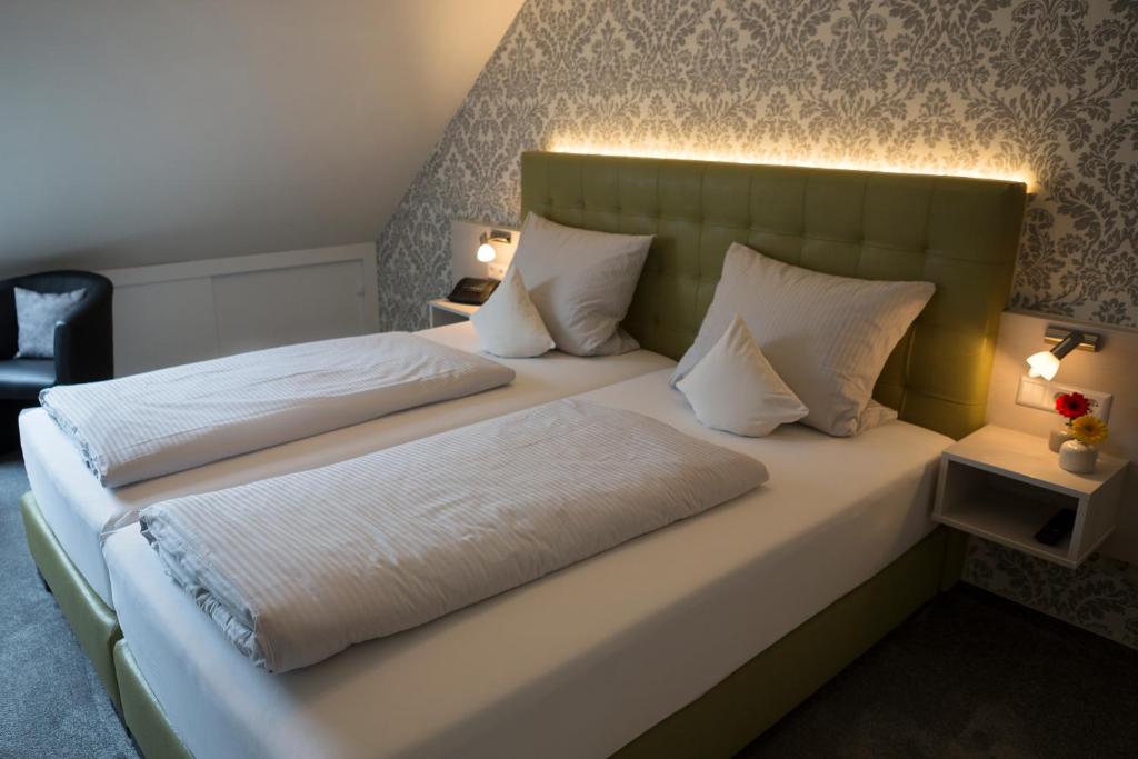 una camera con 2 letti con cuscini bianchi di Weingut Stiftshof a Enkirch