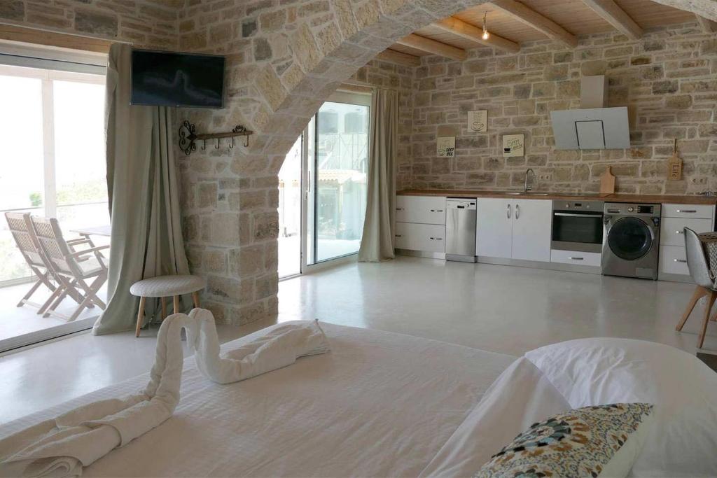a large living room with a stone wall at VILLA SELINI LUXURY APARTMENT in Matala