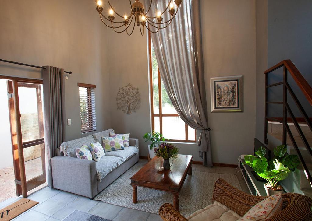 sala de estar con sofá y mesa en Culemborg Cottage en Ciudad del Cabo