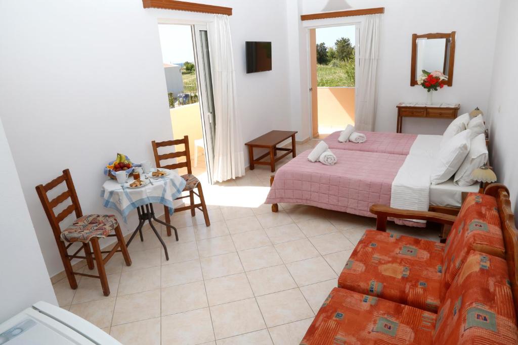 a bedroom with a bed and a table and chairs at Athina in Rethymno