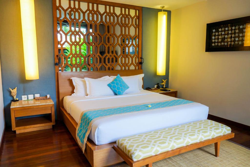 a bedroom with a large bed and a window at Maca Villas & Spa Bali in Seminyak