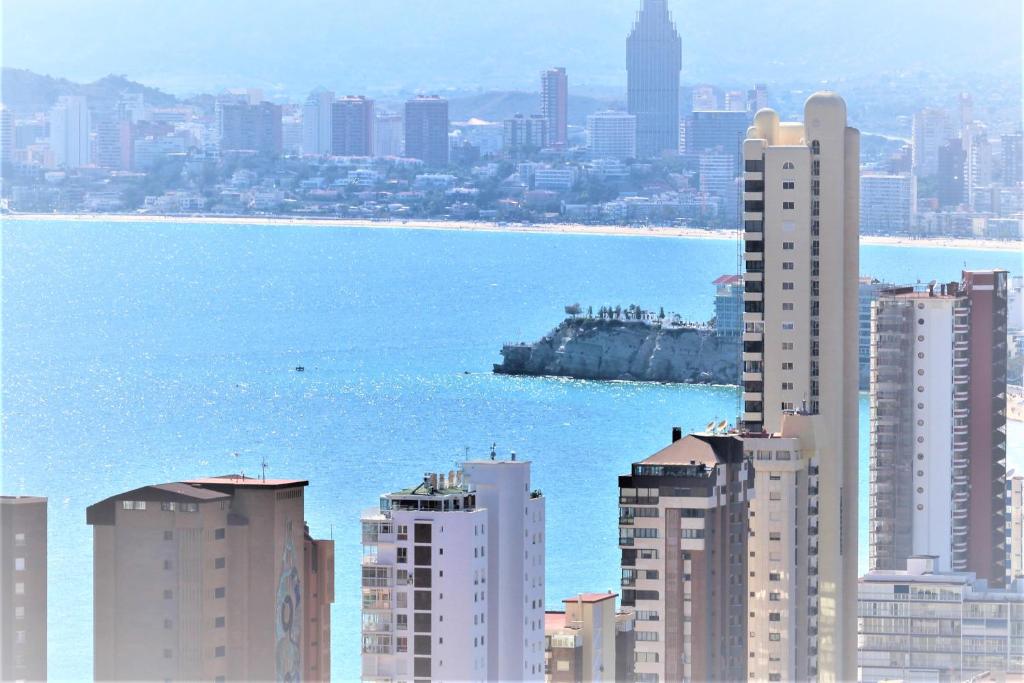 - une vue sur la ville avec ses grands bâtiments et l'eau dans l'établissement Atico Levante Torre Montecarlo, à Benidorm