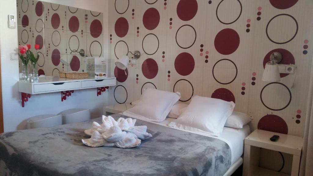 a bedroom with a bed with red circles on the wall at Hostal Flat55Madrid in Madrid