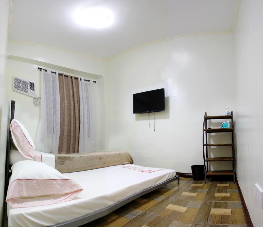 ein Krankenhauszimmer mit einem Bett und einem TV in der Unterkunft Dignadice's Homestay in Coron
