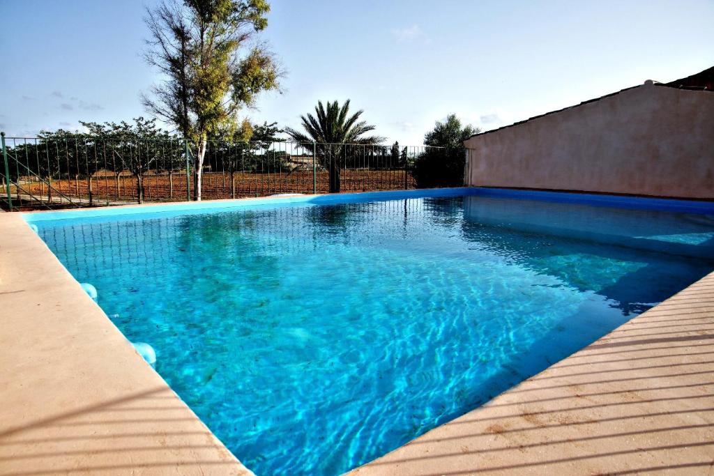 una piscina de agua azul en un patio en Finca Agroturismo Sa Cova den Borino en Campos