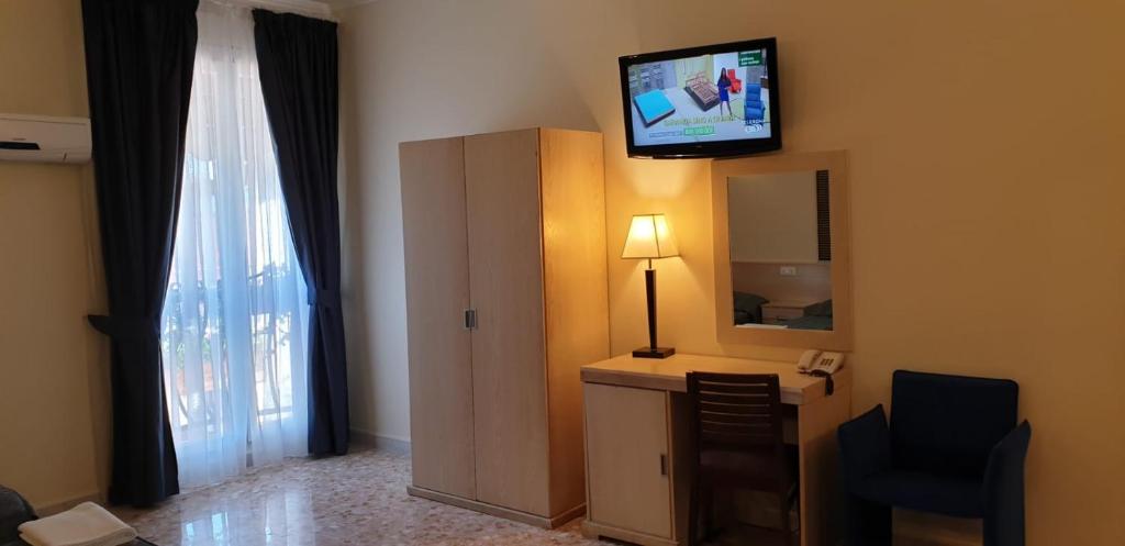 a room with a television and a dresser with a mirror at Hotel Chopin in Fiumicino