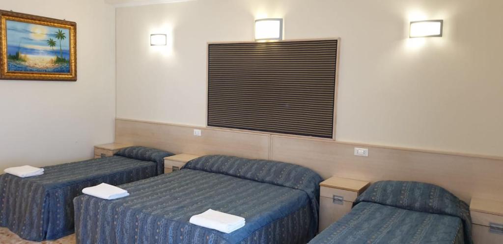 a waiting room with two beds and a window at Hotel Chopin in Fiumicino