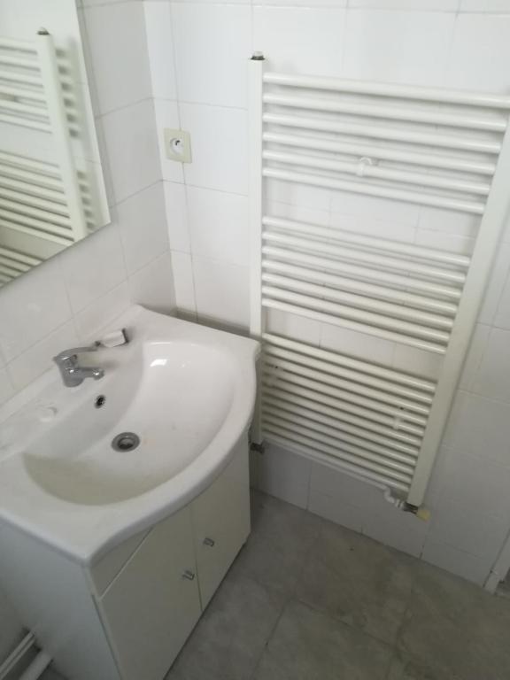 a white bathroom with a sink and a mirror at A 20 minutes de Paris in Sarcelles