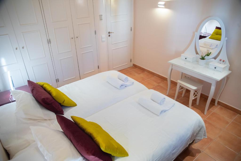 a bedroom with two beds and a mirror at Colina Verde Resort in Moncarapacho