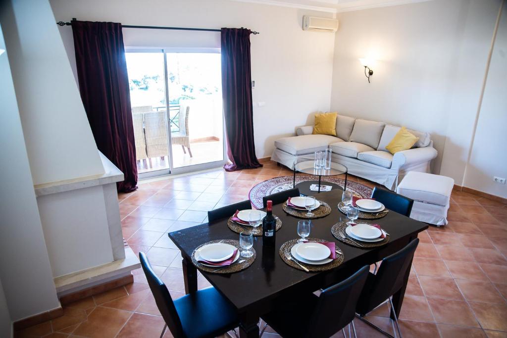 a living room with a black table and chairs at Colina Verde Resort in Moncarapacho