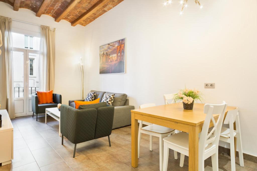 uma sala de estar com uma mesa e um sofá em Stay U-nique Apartments Eixample Center em Barcelona