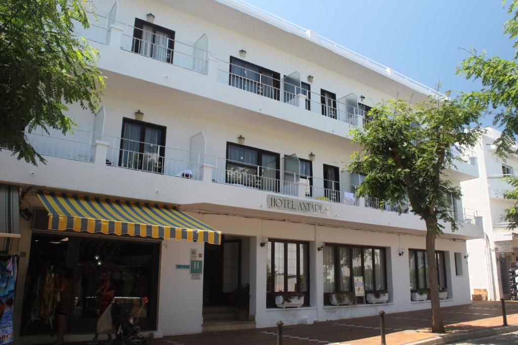 duży biały budynek z przodu sklepu w obiekcie Hotel Antares w mieście Cala d´Or