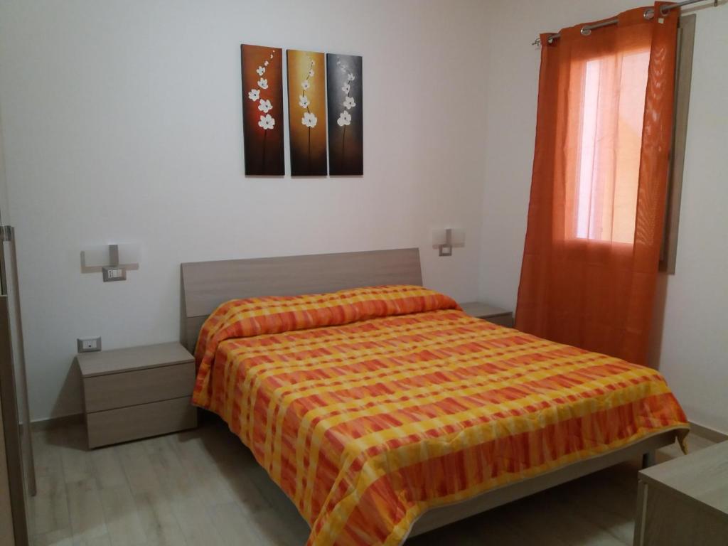 サンタンティーオコにあるCasa Vacanze La Pintaderaのベッドルーム1室(オレンジ色の毛布付きのベッド1台付)