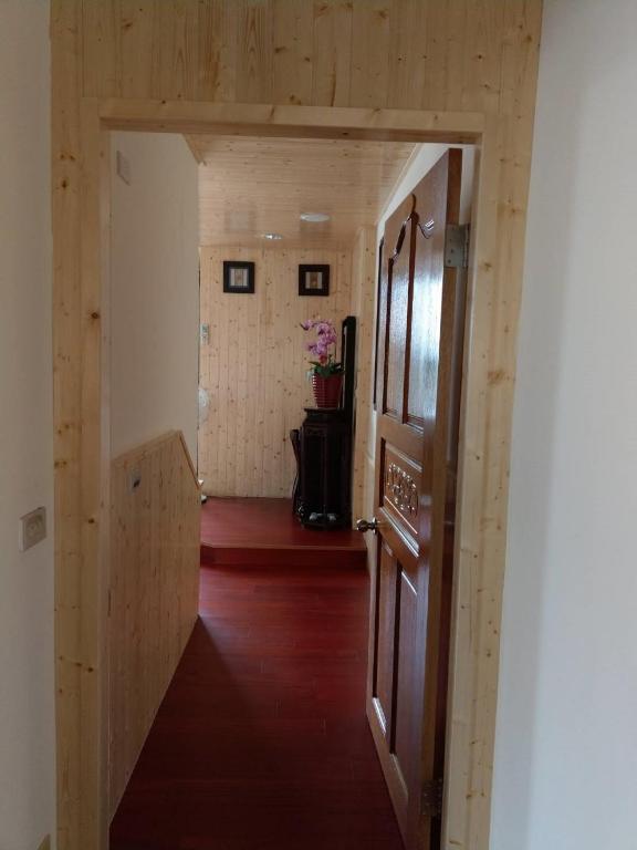 a hallway with a door to a room with wood floors at Yuan-Yee Homestay in Jiufen