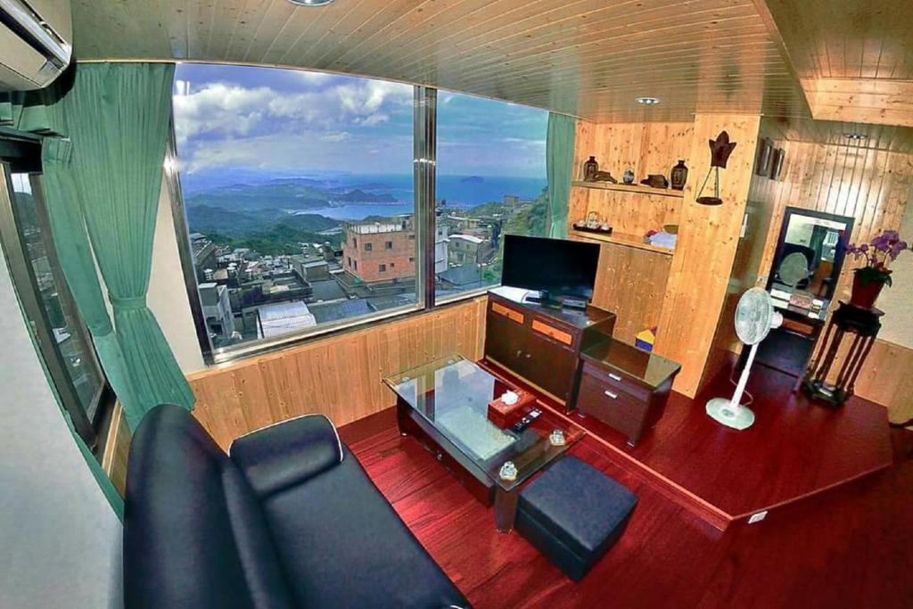 a living room with a large window and a couch at Yuan-Yee Homestay in Jiufen