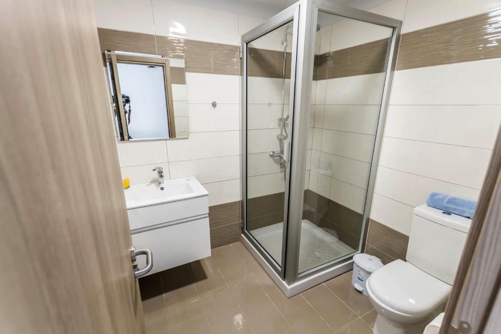 a bathroom with a shower and a toilet and a sink at Bellini Hotel in Ayia Napa