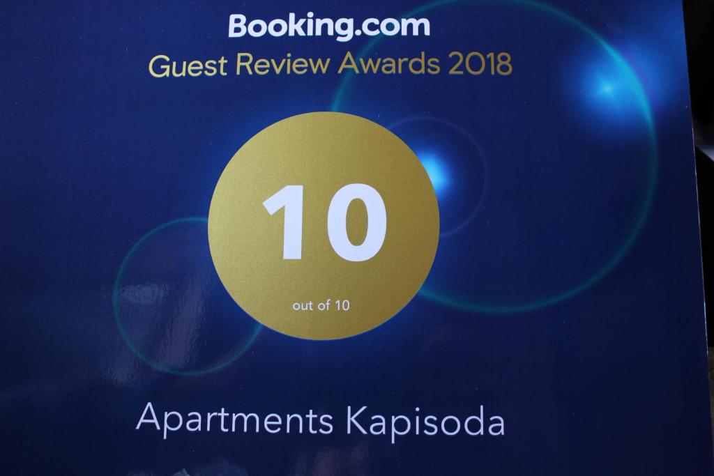 um cartaz para os prémios Quest Review com um círculo amarelo em Apartments Kapisoda em Cetinje