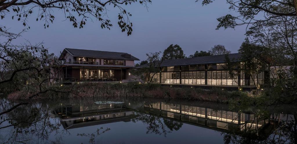 余杭的住宿－杭州木守西溪酒店，前面有池塘的房子