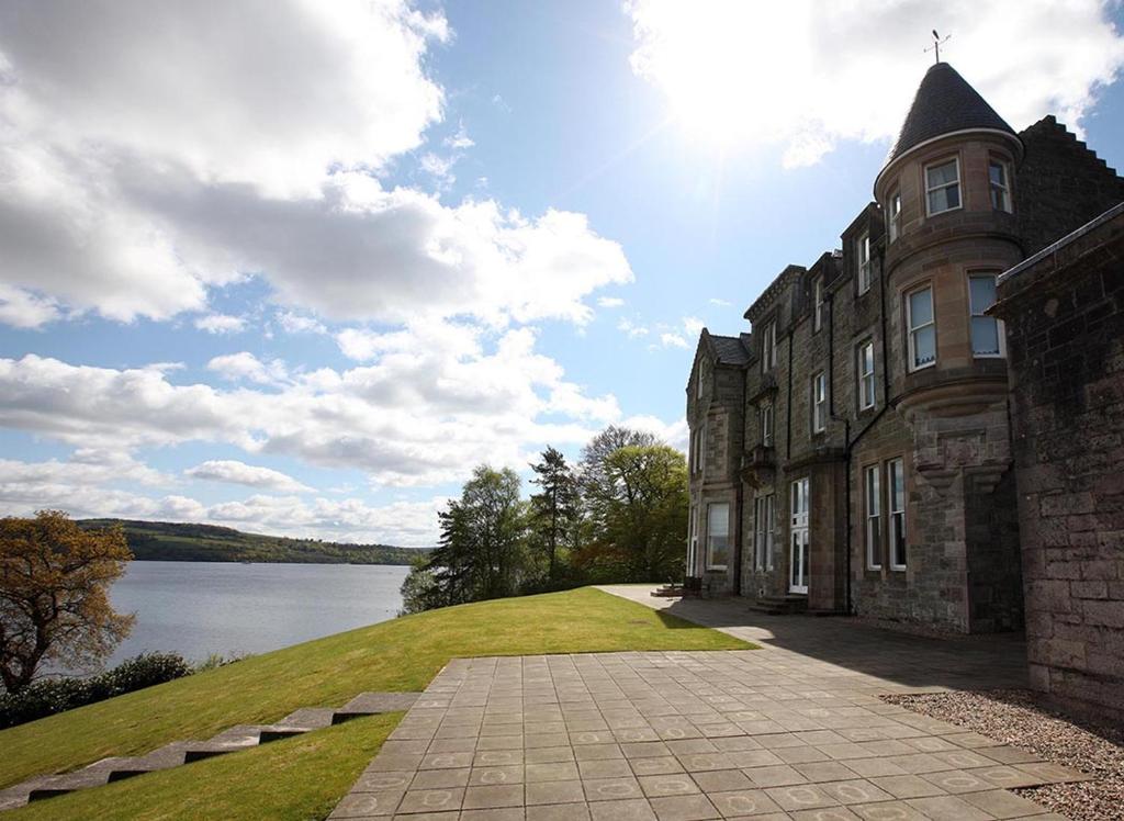 a large building with a view of a body of water at 4 Lomond Castle in Balloch