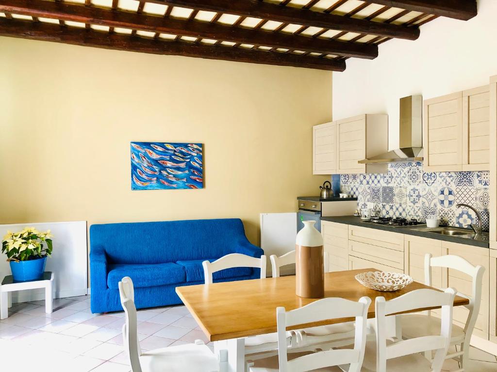 un soggiorno con tavolo e divano blu di Asmara 10 a Trapani
