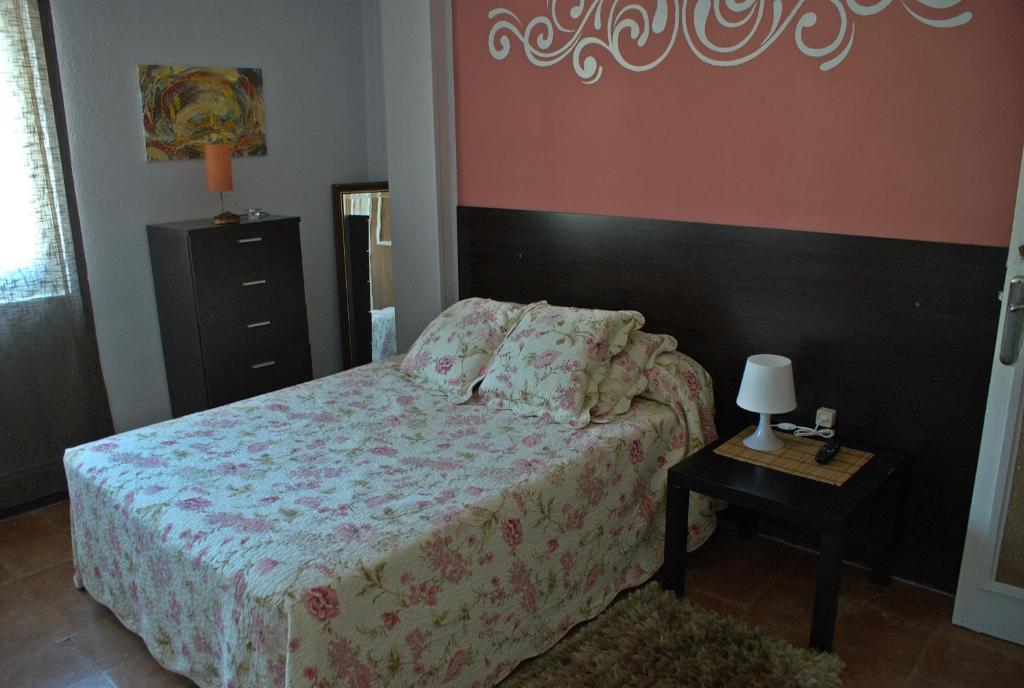 a bedroom with a bed and a table with a lamp at Pensión El Parque in Avilés