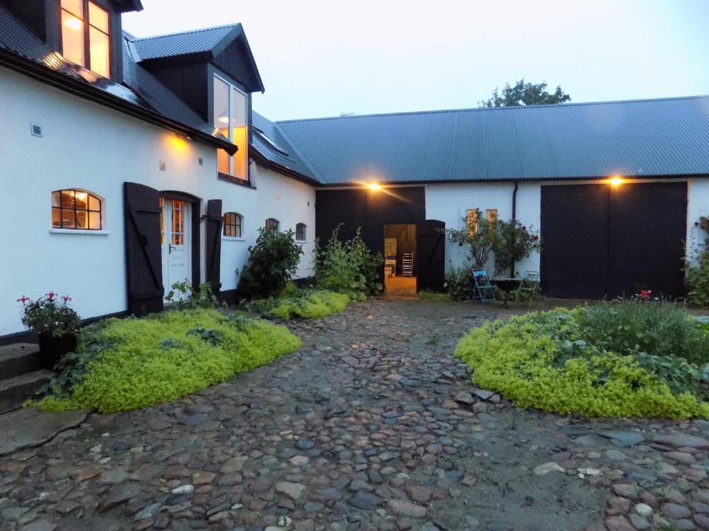 a house with a gravel driveway in front of it at Wingårdhs B&B Österlen in Löderup