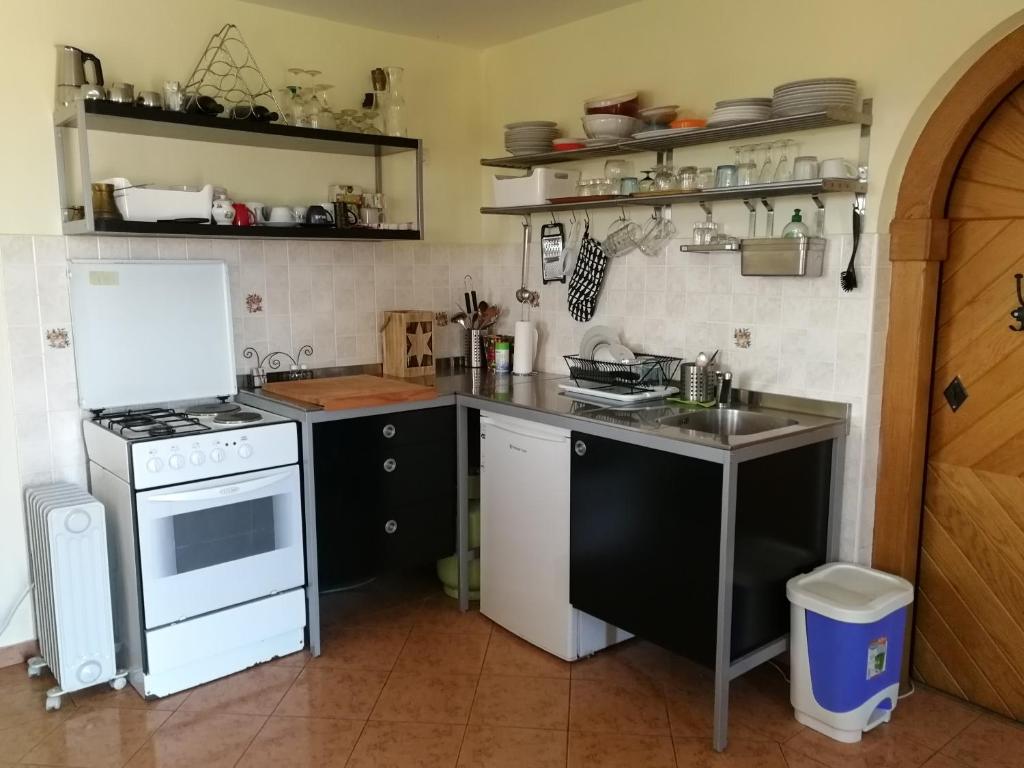 a kitchen with a white stove and a sink at Peaceful, cosy cottage near Kolpa river in Gradac