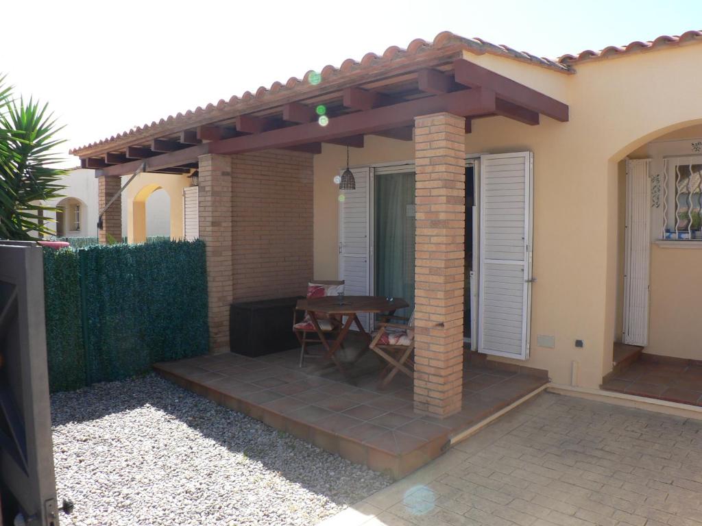 a patio with a wooden table under a pergola at Mas Pinell 129 in Torroella de Montgrí