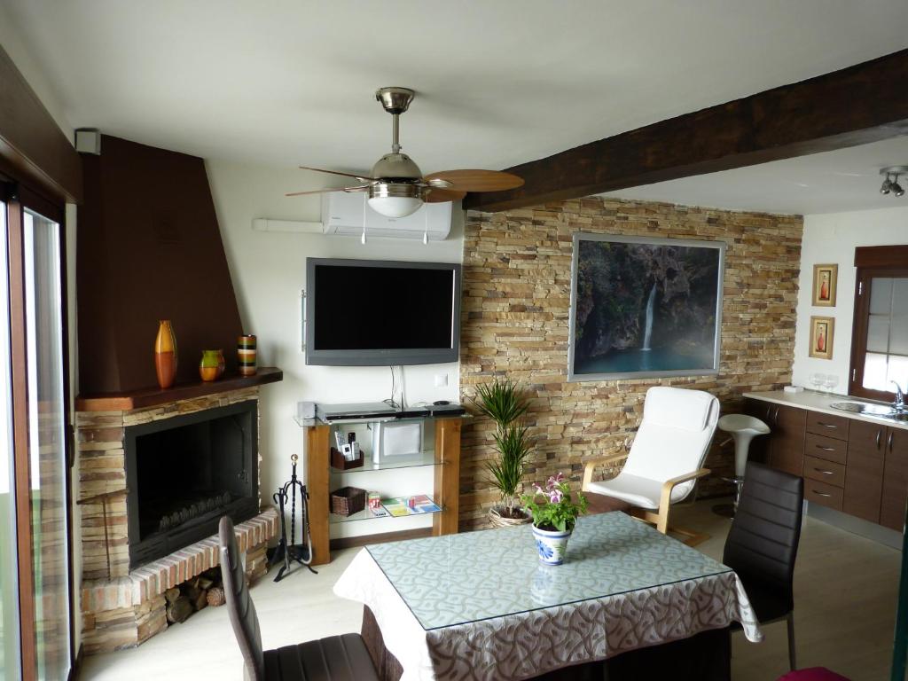 ein Wohnzimmer mit einem Tisch und einem Kamin in der Unterkunft Casa Rincón de Cazorla in Cazorla