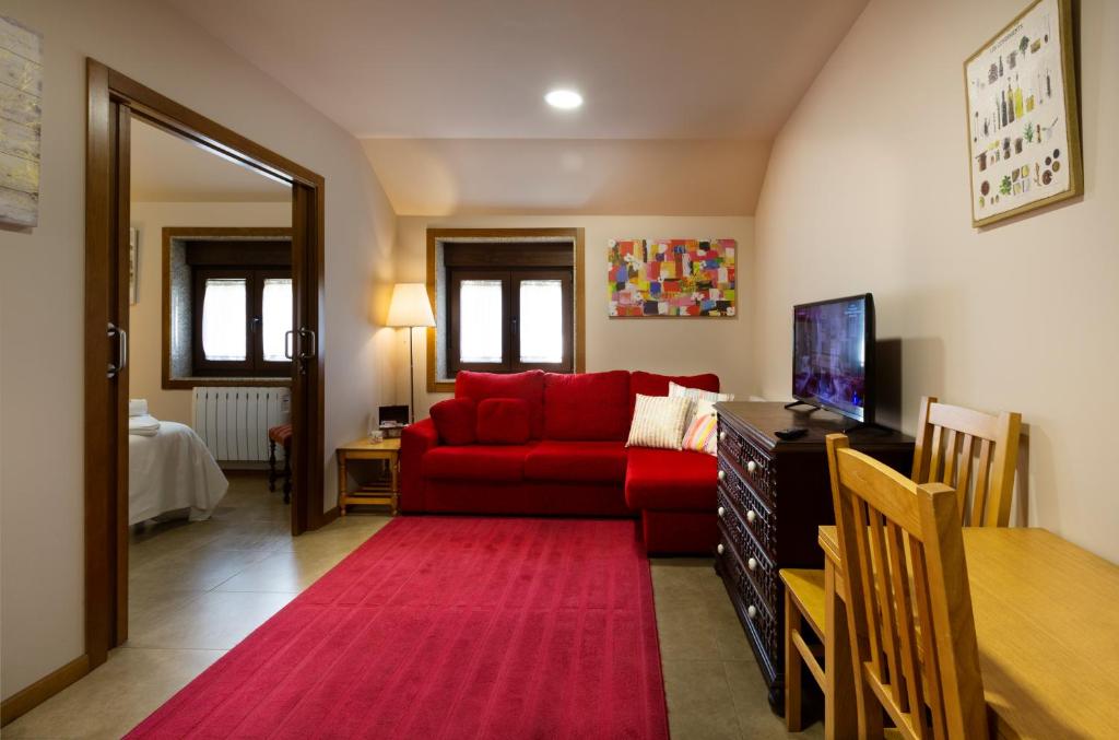 a living room with a red couch and a red rug at Casa A Marchanta in Poio
