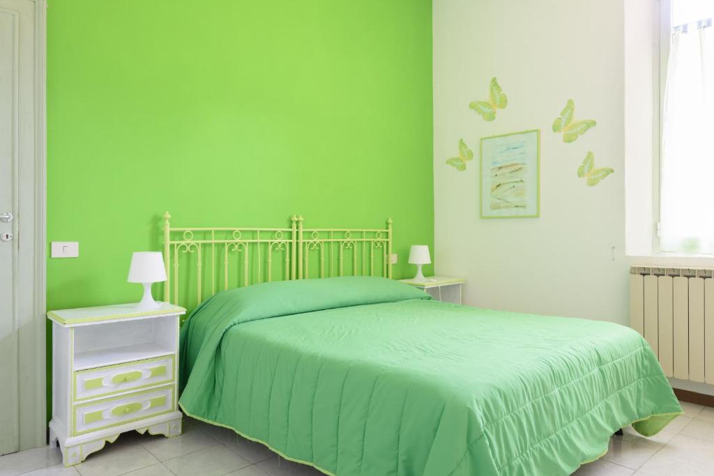 1 dormitorio verde con 1 cama y 2 mesitas de noche en Casa di Osio - Porta Romana, en Siena