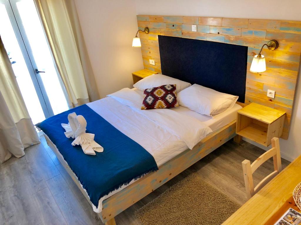 a bedroom with a large bed with a wooden headboard at Boho House in Pakoštane