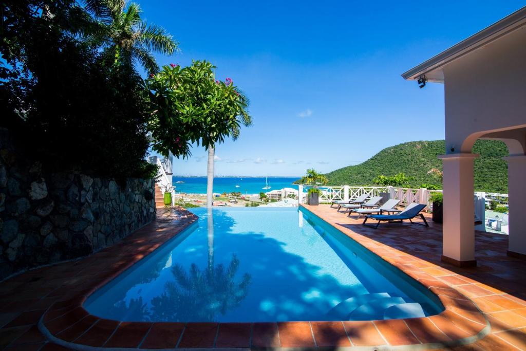 a swimming pool with a view of the ocean at Dream Villa Anse Marcel 546 in Anse Marcel 