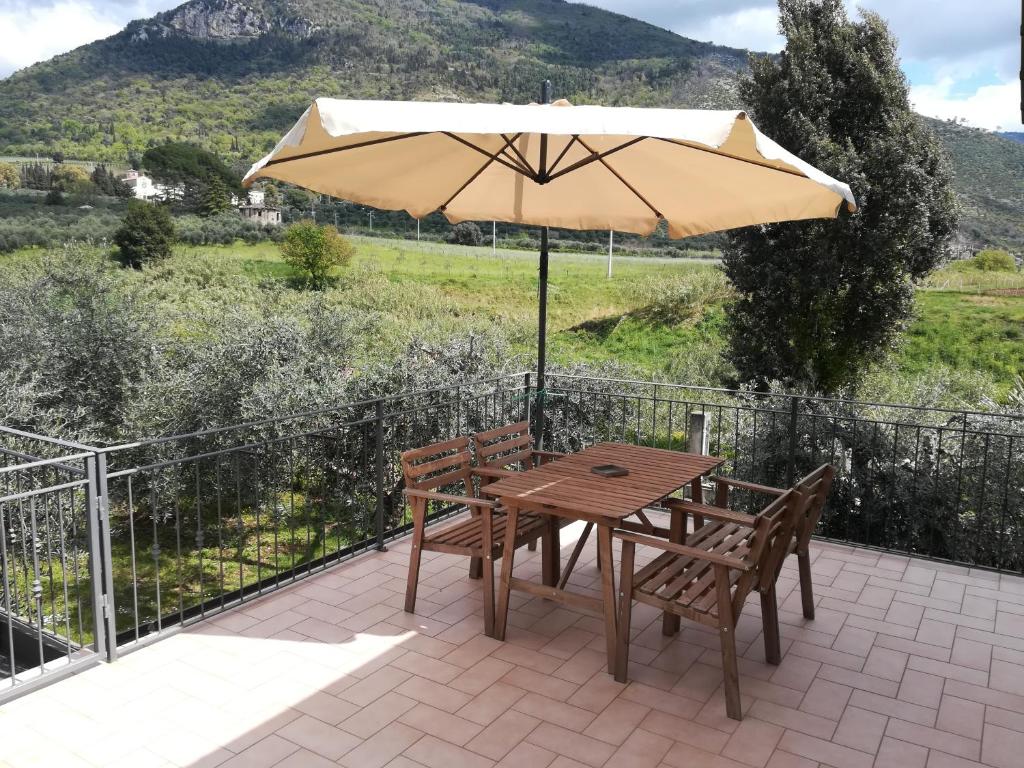 un tavolo e due sedie e un ombrellone su un patio di L'oasi di Alice a Sermoneta