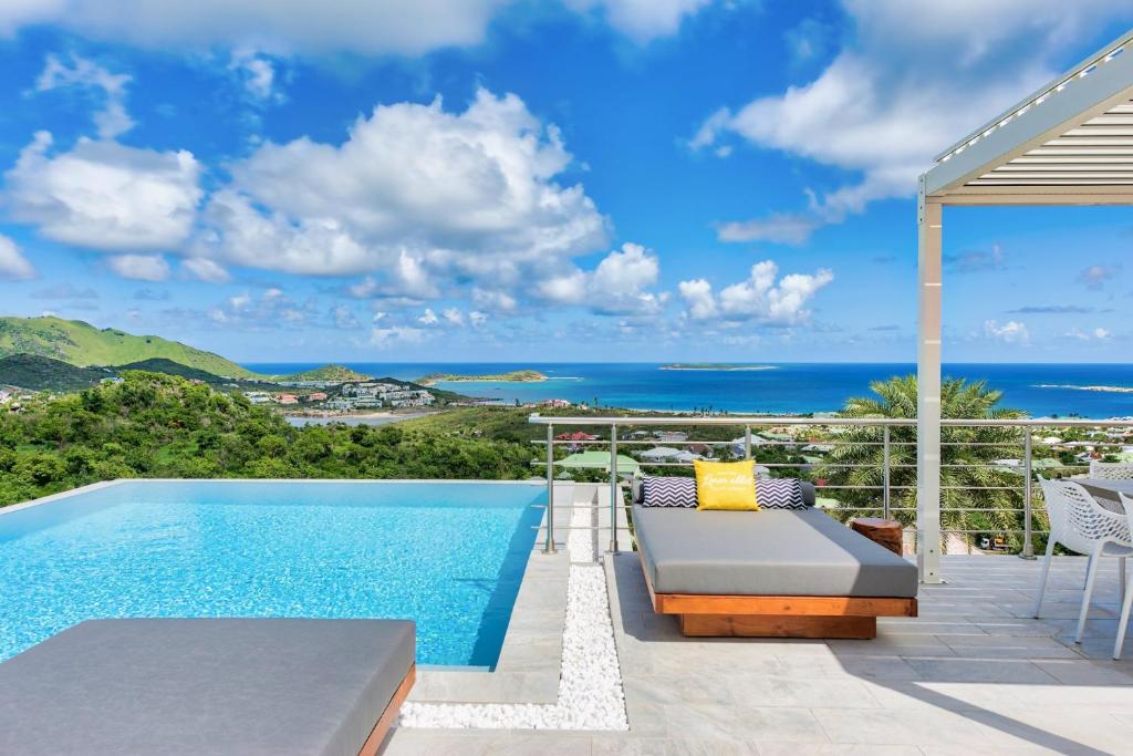 a villa with a swimming pool and the ocean at Dream Villa Orient Bay 566 in Orient Bay