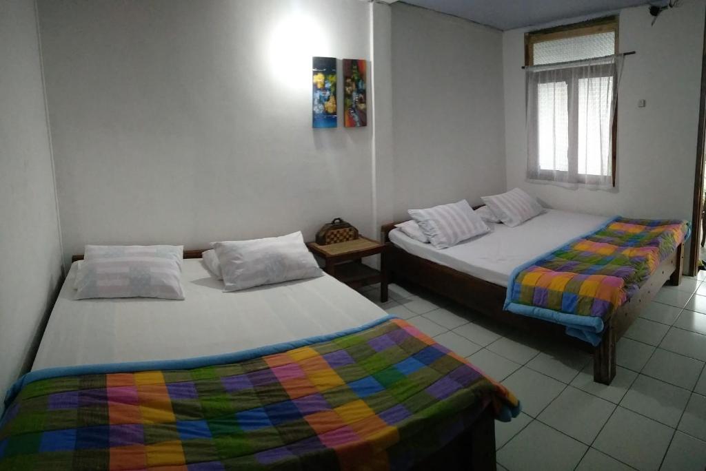 a bedroom with two beds and a window at Bromo Tanjung in Tosari