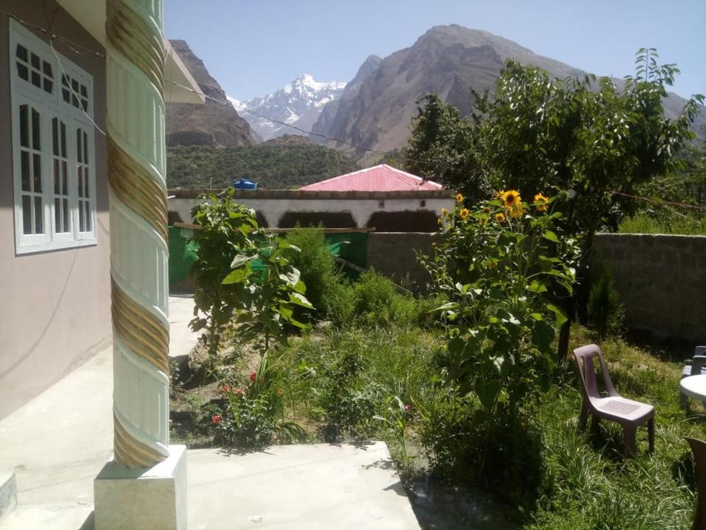 a view of a garden with mountains in the background at Four Seasons Guest House Hunza in Hunza Valley