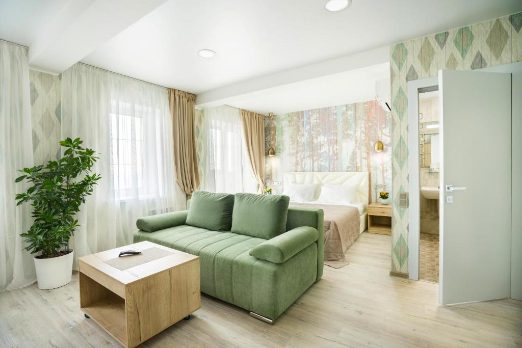 a living room with a green couch and a bed at Hotel Chalet in Vladivostok