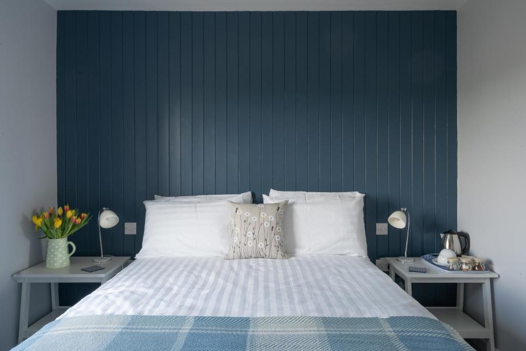 a bedroom with a bed with a blue wall at Ty Ffynnon B&B in Tenby