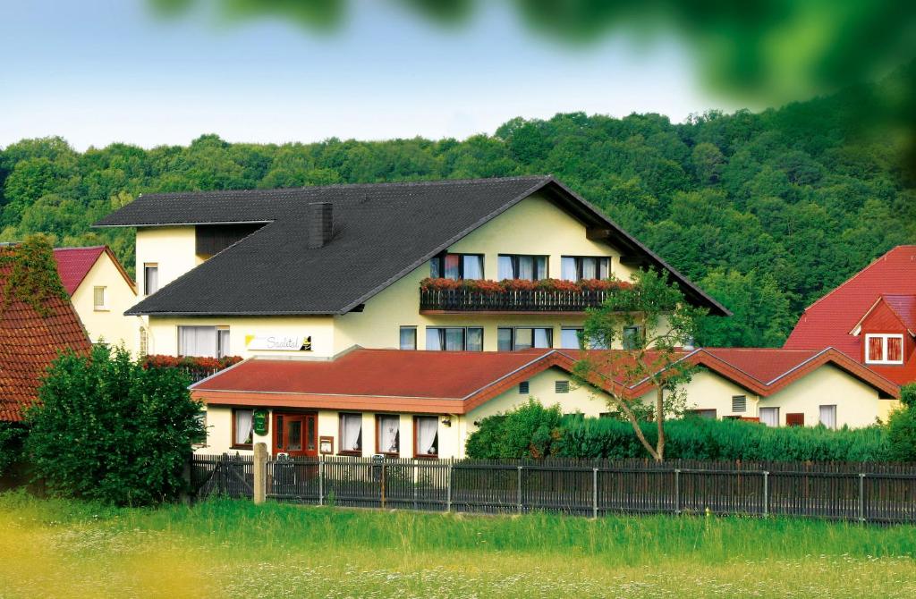 una gran casa blanca con techo negro en Saaletal Pension & Ferienwohnungen, en Bad Bocklet
