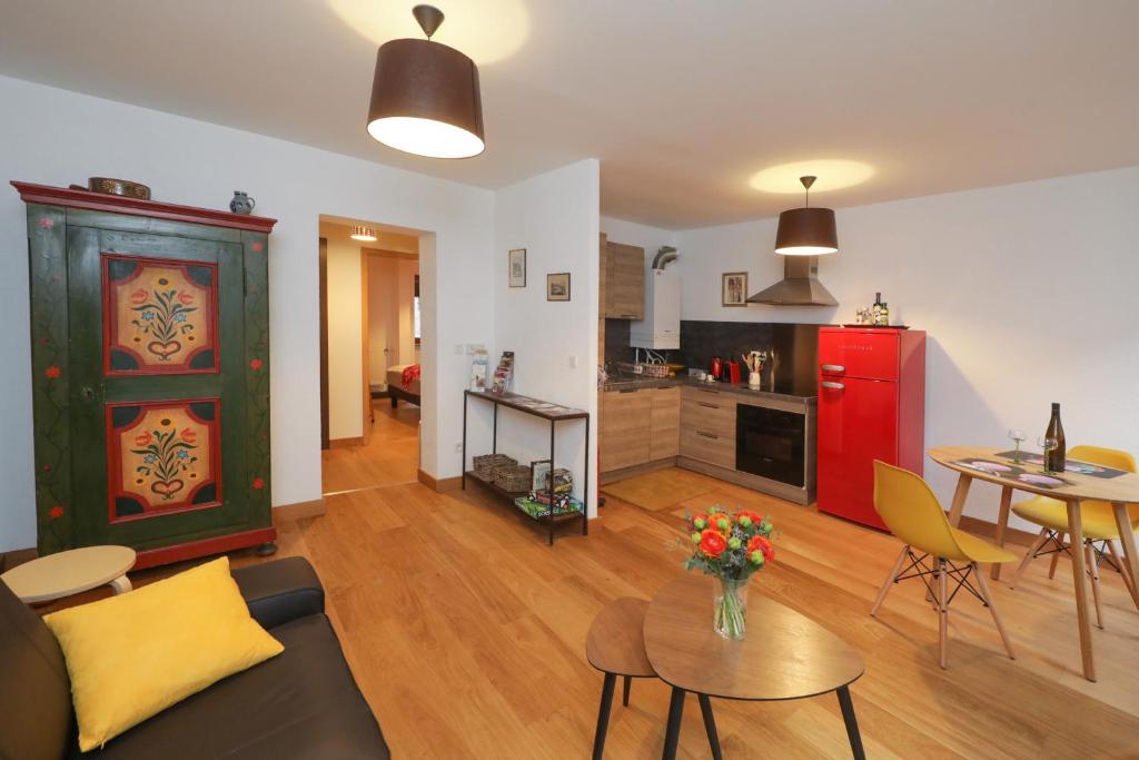 - un salon avec un canapé et un réfrigérateur rouge dans l'établissement Au buisson de roses, à Colmar