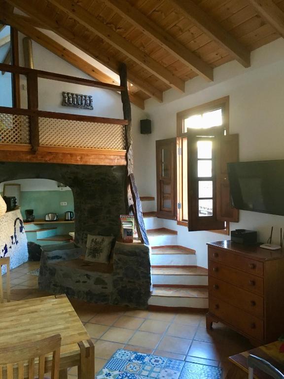 salon z kamiennym kominkiem i telewizorem w obiekcie Casa Ambiente w mieście Valle Gran Rey