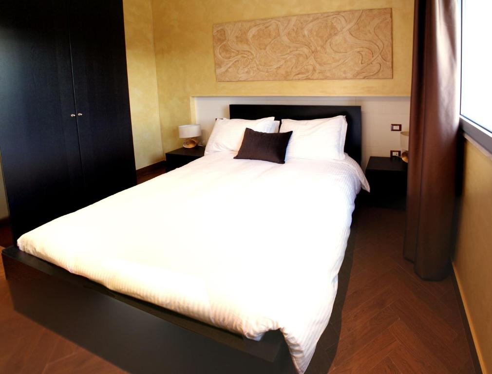 a bedroom with a large bed with white sheets and pillows at Garden Holiday in Marina di Melilli