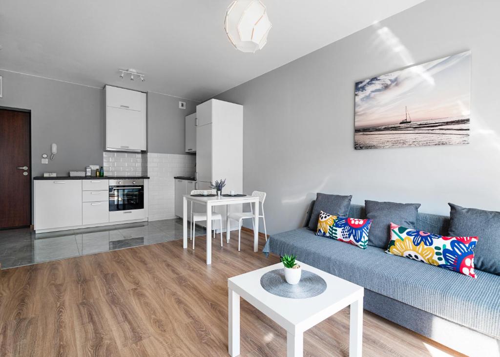 Il comprend un salon avec un canapé bleu et une cuisine. dans l'établissement Warszawa-Włochy Brilliant Apartment, à Varsovie