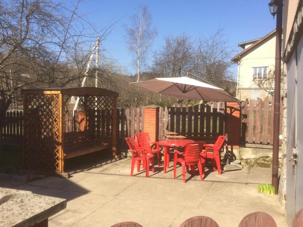 een patio met een tafel en stoelen en een parasol bij Будиночок в Східнці-Новий Кропивник in Skhidnitsa