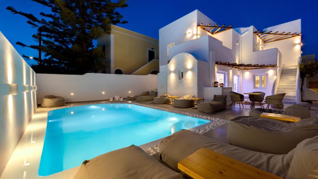 a villa with a swimming pool at night at Emerald Collection Suites in Karterados